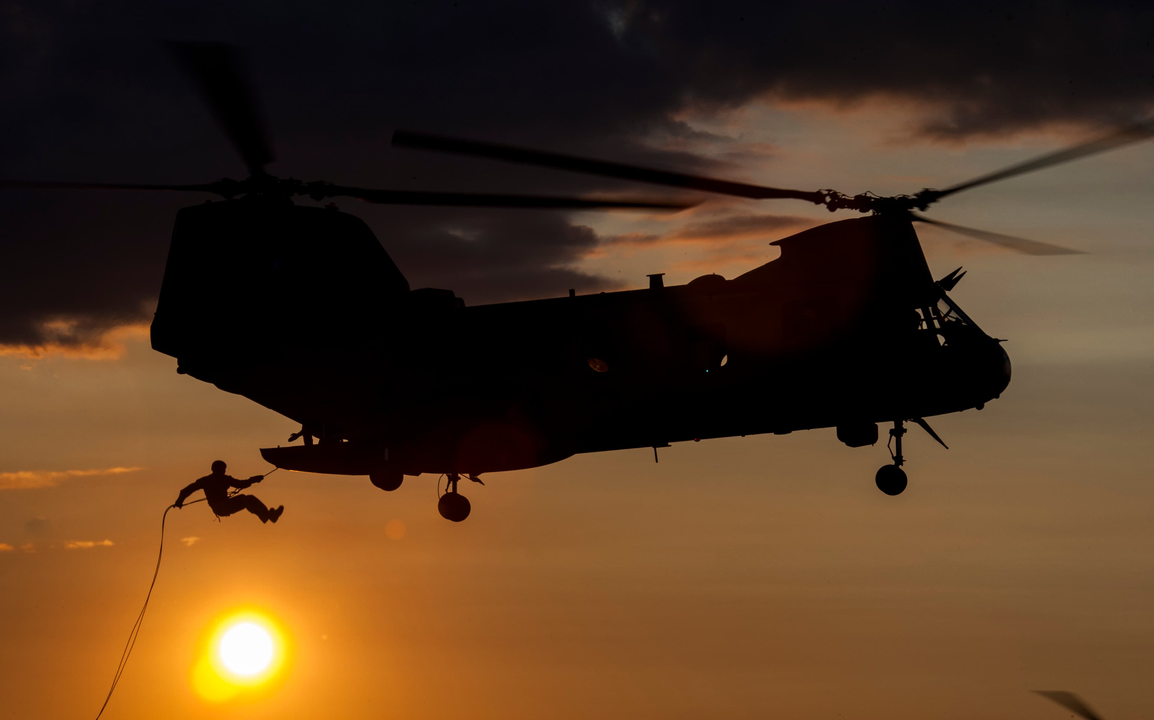 Helicopter extraction silhouette at sunset
